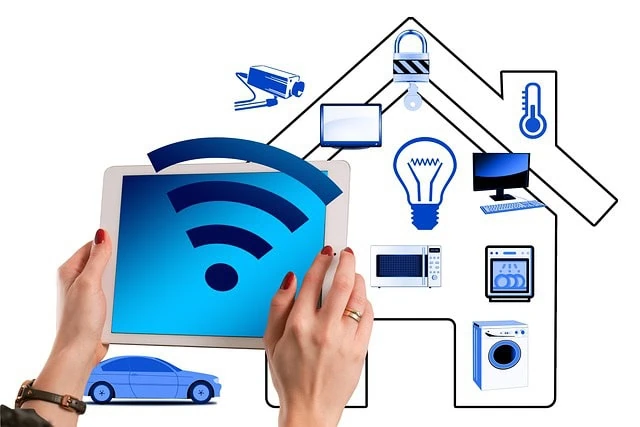 Mains tenant une tablette affichant un symbole Wi-Fi, entouré d'icônes d'appareils intelligents comme une caméra de sécurité, une ampoule et une voiture, le tout dans le cadre d'un domicile intelligent
