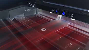 Vue rapprochée d'un scanner à plat en fonctionnement, avec des lumières laser rouges visibles et des marqueurs d'alignement sur la surface de numérisation, idéal pour une numérisation de documents rapide et pas chère.