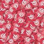 Une pile de carreaux carrés rouges arborant le logo blanc de Pinterest souligne l’engagement indéniable de la plateforme à améliorer la visibilité dans l’activité des médias sociaux.